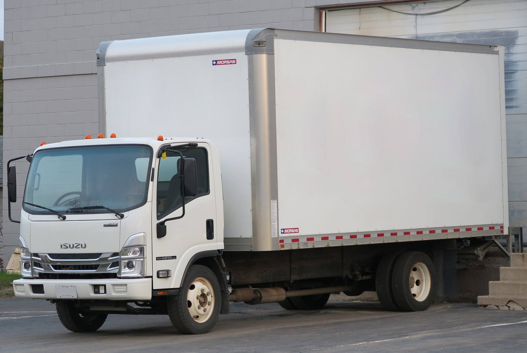 White straight truck with a box body at a loading dock