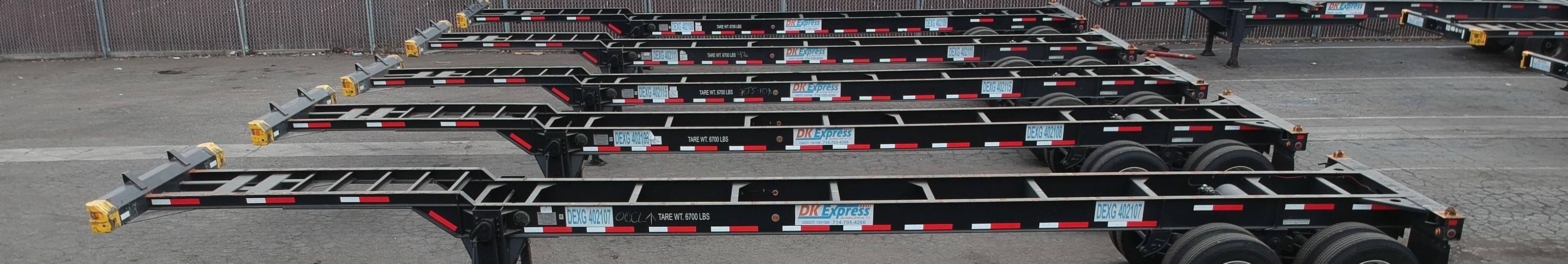 Row of container chassis marked with DK Express decals and DEXG numbers